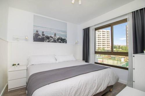 Un dormitorio blanco con una cama grande y una ventana en Ocean House Bloque 3 Planta 1 By IVI Real Estate, en Torremolinos