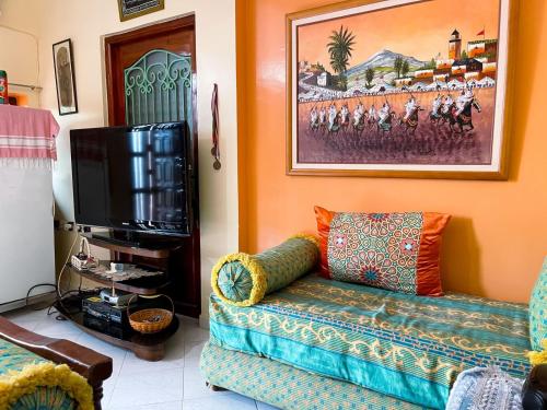 a living room with a couch and a tv at Maison avec piscine et grand jardin 1 hectare in Marrakech