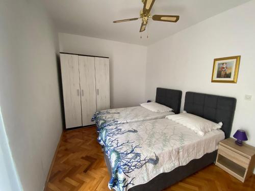 a bedroom with a bed and a ceiling fan at Apartments Helena in Primošten