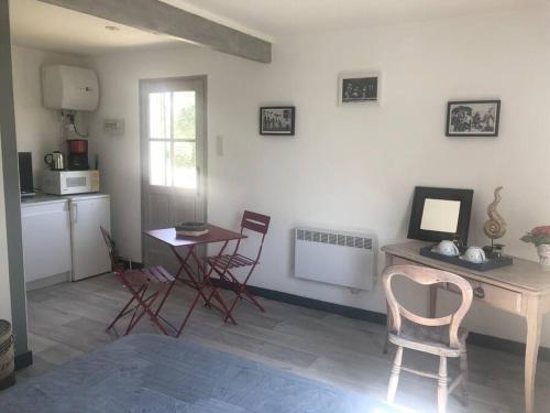 - une cuisine avec une table et des chaises dans la chambre dans l'établissement STUDIO EN AUVERGNE Le ruisseau, à Saint-Priest-Bramefant