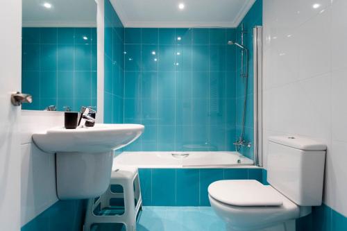 オンダリビアにあるHondarribia by Basquelidaysの青いタイル張りのバスルーム(トイレ、シンク付)