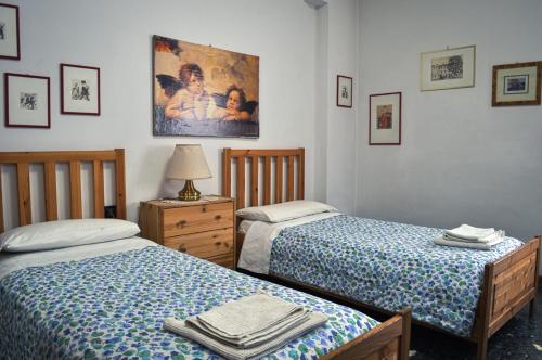 1 dormitorio con 2 camas, lámpara y una foto en Bed And Breakfast Arcobaleno, en Bolonia