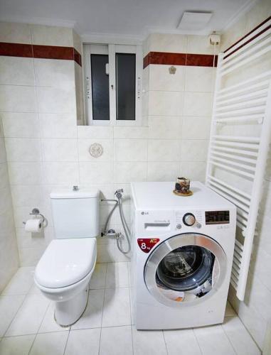 a bathroom with a toilet and a washing machine at Lili's Apartment in Eleusis