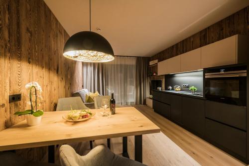 a kitchen and dining room with a wooden table at K1 Mountain Chalet - Luxury Apartements in Brunico