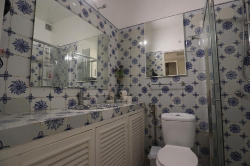 W łazience znajduje się toaleta, umywalka i lustro. w obiekcie Rua das Arcadas do Parque 52 w mieście Estoril