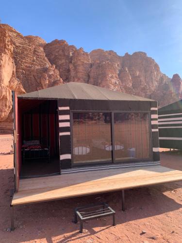 a small building with a black roof in the desert at Bedouin friend camp in Wadi Rum