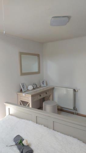 a bedroom with a desk with a mirror and a bed at Gyulai idill apartman in Gyula