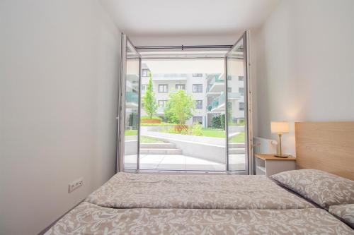 una camera con un letto e una grande porta scorrevole in vetro di Corvin Modern Two Bedroom Apartment FREE PARKING a Budapest