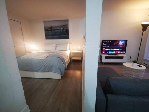Schlafzimmer mit einem Bett und einem Flachbild-TV in der Unterkunft Lovely studio in Longueuil, near Downtown Montreal in Longueuil