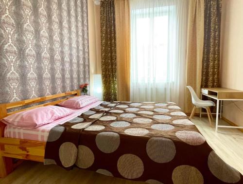 sypialnia z łóżkiem, biurkiem i oknem w obiekcie Aпартаменти в центрі, дві кімнати w Lwowie