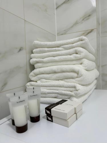 stos ręczników i świec na stole w łazience w obiekcie Apartament Rose w mieście Gura Humorului