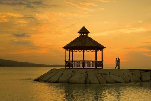 two people standing on a small island in the water at Secrets Wild Orchid Adults Only - All Inclusive in Montego Bay