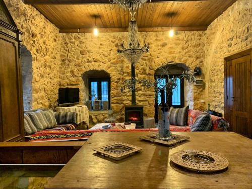 a living room with a table and a stone wall at Beit el Deif in Jbeil