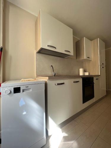 a kitchen with white cabinets and a dishwasher at Al Lago da Lilly in Gargnano