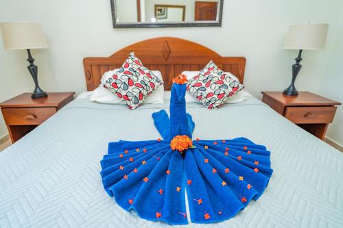 a blue dress on a bed with two night stands at Agualina Kite Hotel Oceanfront Apartments in Cabarete