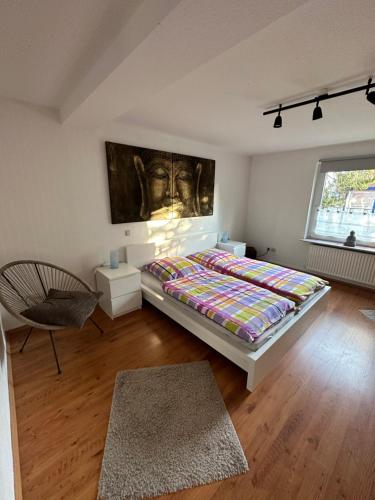 1 dormitorio con 1 cama, 1 silla y 1 ventana en Mühlenloft Hameln, en Hessisch Oldendorf
