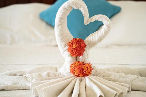 a white dress with orange flowers on a bed at Agualina Kite Hotel Oceanfront Apartments in Cabarete