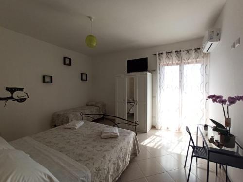 a bedroom with a bed and a table and a window at B&B In Sella in Vico Equense