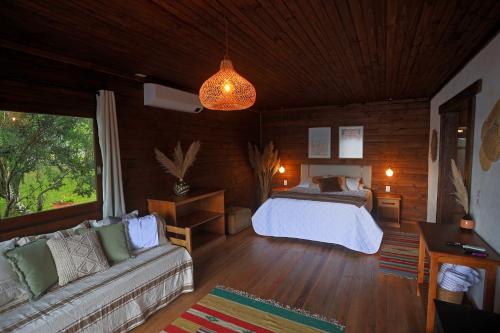 a bedroom with a bed and a couch in a room at Aires de Patagonia in Cambara do Sul