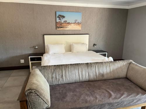 a bedroom with a bed and a couch at Thabazimbi Country Lodge in Thabazimbi