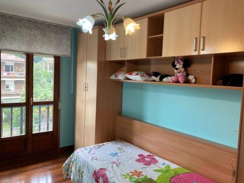 sypialnia z łóżkiem i niebieską ścianą w obiekcie Bella Vista w mieście Ramales de la Victoria