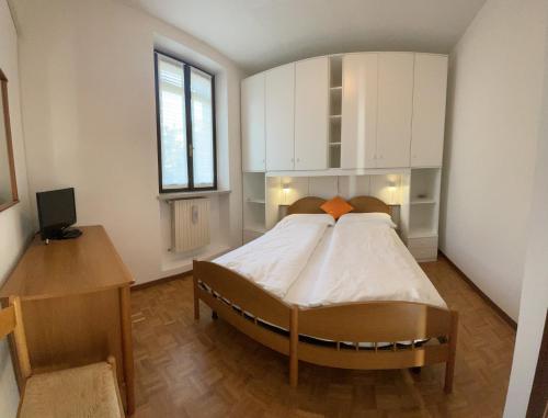 a bedroom with a large bed and a desk at Appartamento alla Playa in Brenzone sul Garda