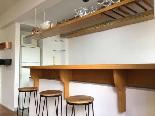 a kitchen with three bar stools under a counter at Departamento en Palermo Parking included in Buenos Aires