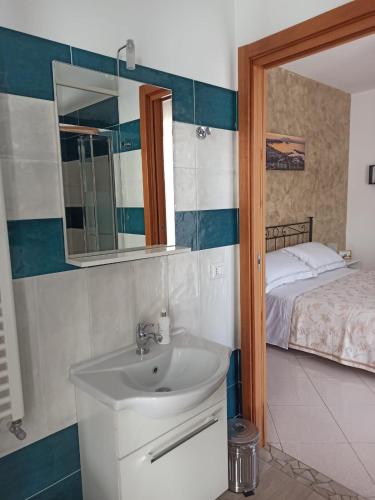 a bathroom with a sink and a mirror and a bed at B&B In Sella in Vico Equense