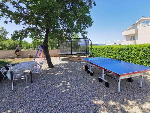 uma mesa de pingue-pongue azul e um baloiço em Apartments Lea with pool em Malinska