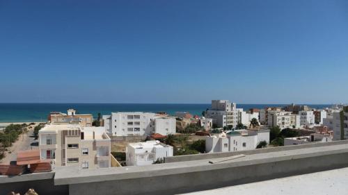 a view of a city with buildings and the ocean at The Pearl Apartment Hammam Sousse WIFI in Sousse