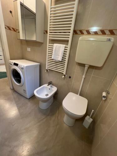 a bathroom with a toilet and a sink and a washing machine at Cesare Battisti Home in Bologna