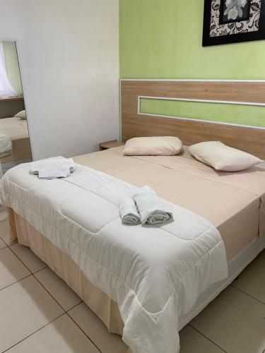 een slaapkamer met een bed met handdoeken erop bij Pousada Las Palmas in Guarujá