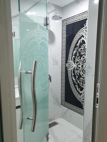 a bathroom with a glass shower with a mirror at Garden Beach Sidi Rahal in Sidi Rahal