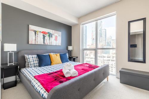 een slaapkamer met een bed en een groot raam bij Luxury 1BR Condo - King Bed - Stunning City View in Toronto