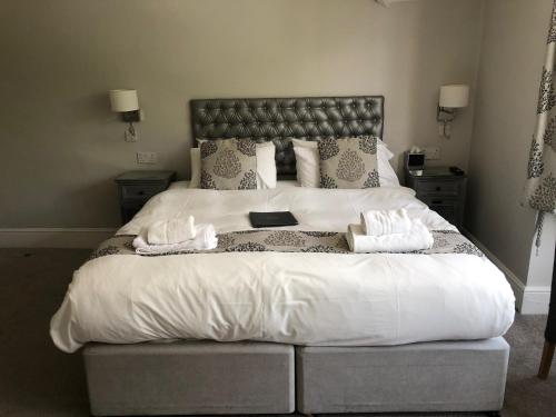 a bedroom with a large bed with two towels at The Maple Manor Hotel in Crawley