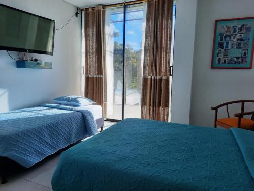a bedroom with two beds and a large window at Casa De Campo in Santuario