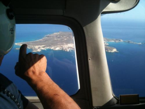 a man giving a thumbs up from the window of an airplane at Lithos Traditional Guest Houses in Xerokampos