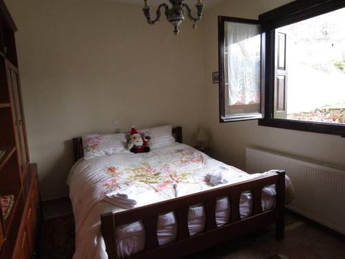 a teddy bear sitting on a bed in a bedroom at Ανάμεσα στα Έλατα in Ayía Varvára