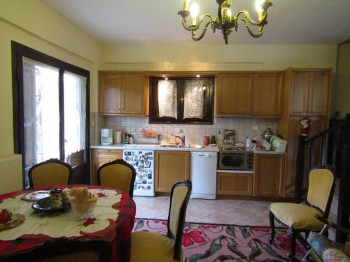 a kitchen with a table and a kitchen with a chandelier at Ανάμεσα στα Έλατα 