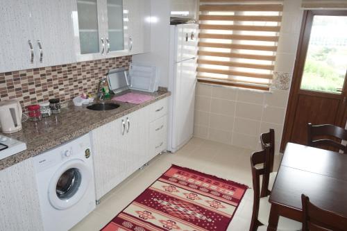 a kitchen with a sink and a washing machine at Konaklar Apart Premium in Trabzon