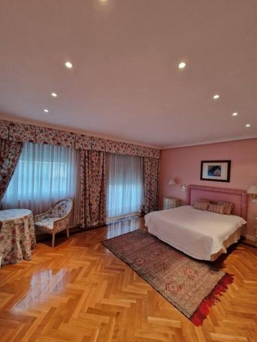 a bedroom with a large bed and a wooden floor at La Casona Imperial in Alpedrete