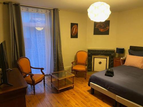 奧比埃的住宿－Bienvenue à la Villa Plagnal Classée 3 étoiles，一间卧室配有一张床、两把椅子和一个壁炉