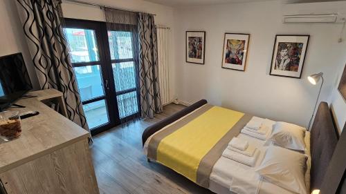 1 dormitorio con 1 cama, TV y ventana en La țărm, en Mangalia