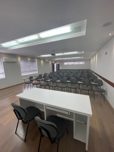 a large room with a white table and chairs at Xikus Palace Hotel in Guanhães
