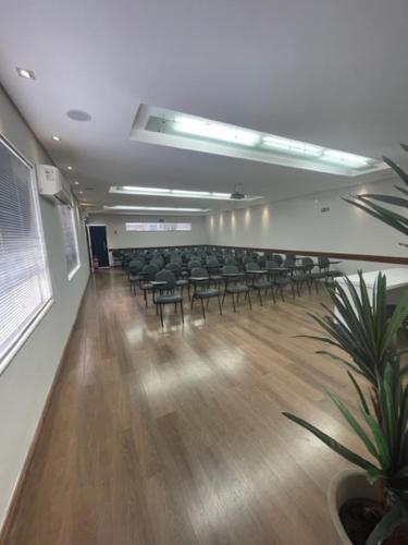 a room with chairs and tables and a room with at Xikus Palace Hotel in Guanhães