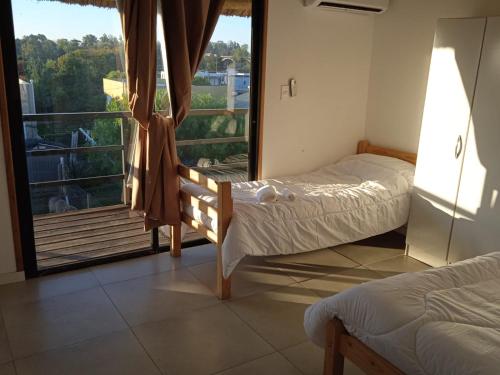 - une chambre avec 2 lits et une grande fenêtre dans l'établissement Posada El Mariscal, à Paso de los Toros