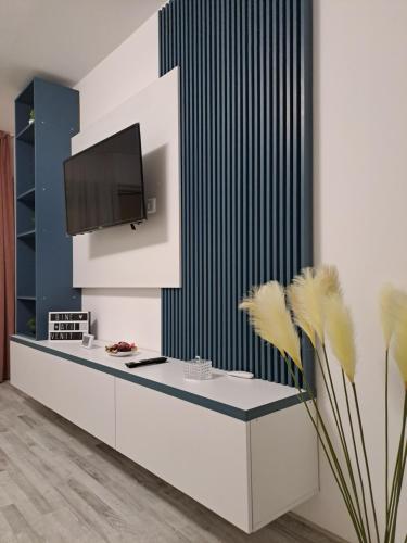 een kamer met een bureau en een tv aan de muur bij Happy Rental Apartments 2 in Craiova