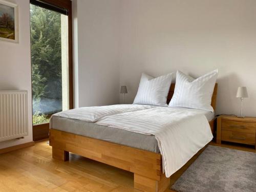 um quarto com uma cama com lençóis brancos e uma janela em Szent Kard Vendégház em Sóly