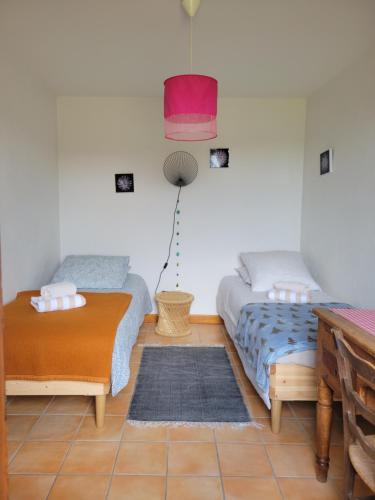 Sala de estar con 2 camas y mesa en Se reconnecter à la nature au gîte 3 étoiles de Montager à Saint André de Chalencon, en Saint-André-de-Chalençon