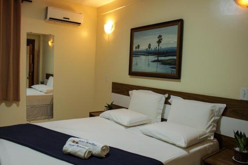 una camera da letto con un grande letto con cuscini bianchi di Hotel Monólitos a Quixadá